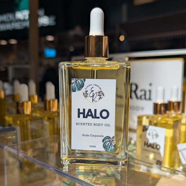100ml clear bottle of Eli and Rai Halo Radiance Boosting Body Oil ($30), a plant-based avocado and camellia seed glowing body oil with a vanilla cashmere scent.